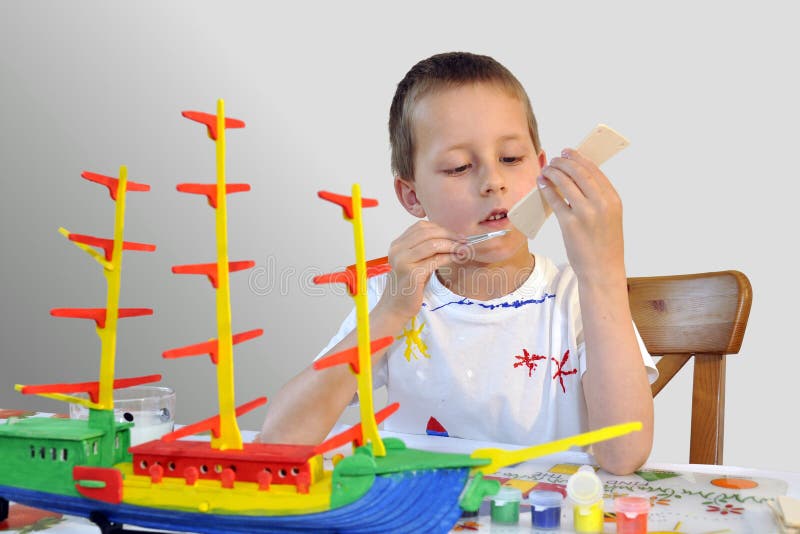 Young boy - woodcraft ship painting, focused