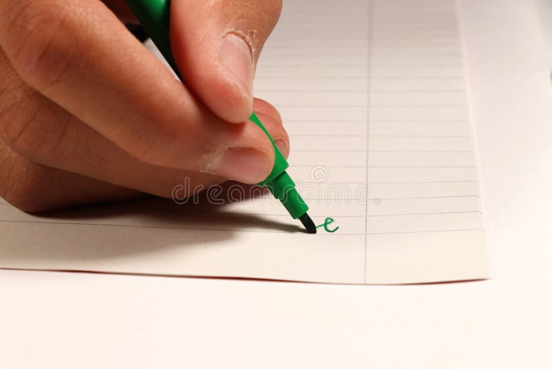A young boy writing with green felt-tip pen a some word on english lesson at elementary school royalty free stock photo A young boy writing with green felt-tip pen a some word on english lesson at elementary school royalty free stock photo