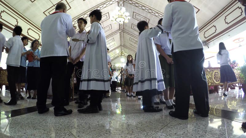 Young boys receive sacrament of communion administered by Roman Catholic priest