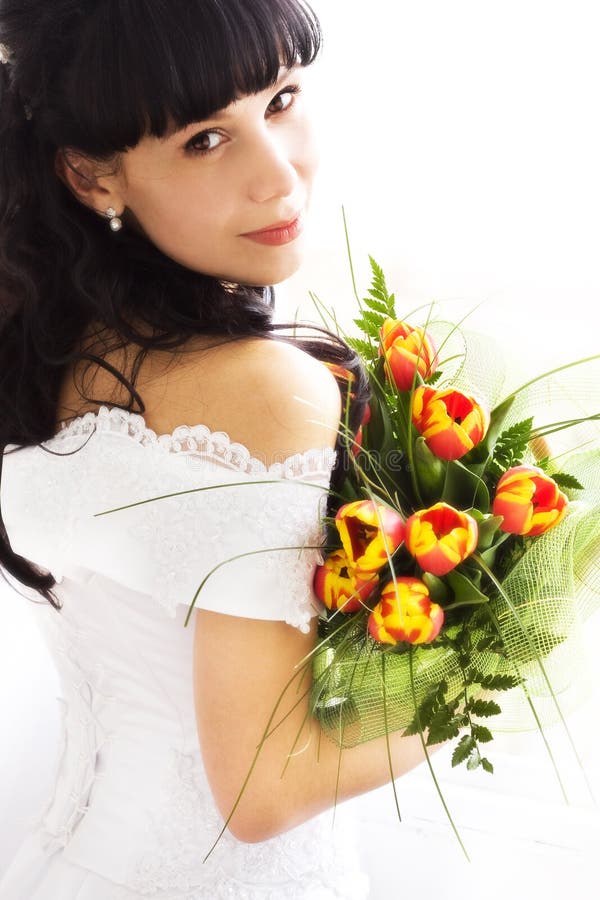 Young bride in wedding wear with bouquet of tulips