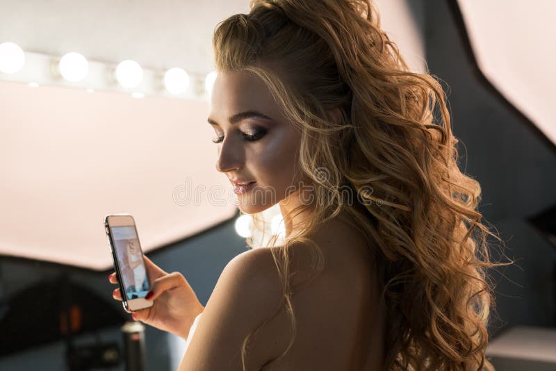 Young bride with nice hair style holding her phone