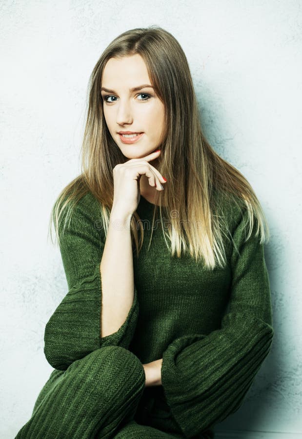 Young brown-haired woman with long hairs dressed in a green knitted suit, relaxation and rest.