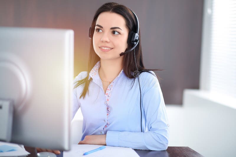Young brunette business woman looks like a student girl working in office. Hispanic or latin american girl talking by stock photo Young brunette business woman looks like a student girl working in office. Hispanic or latin american girl talking by stock photo