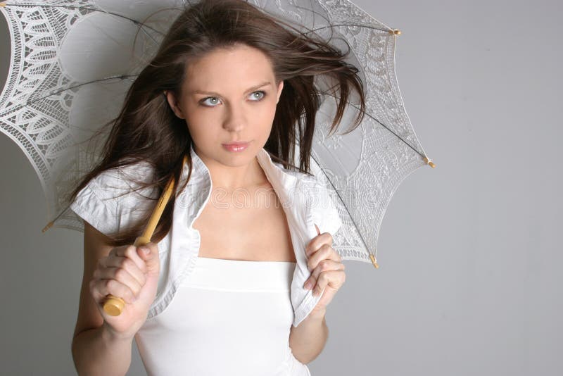 Young brunette girl with umbrella in white