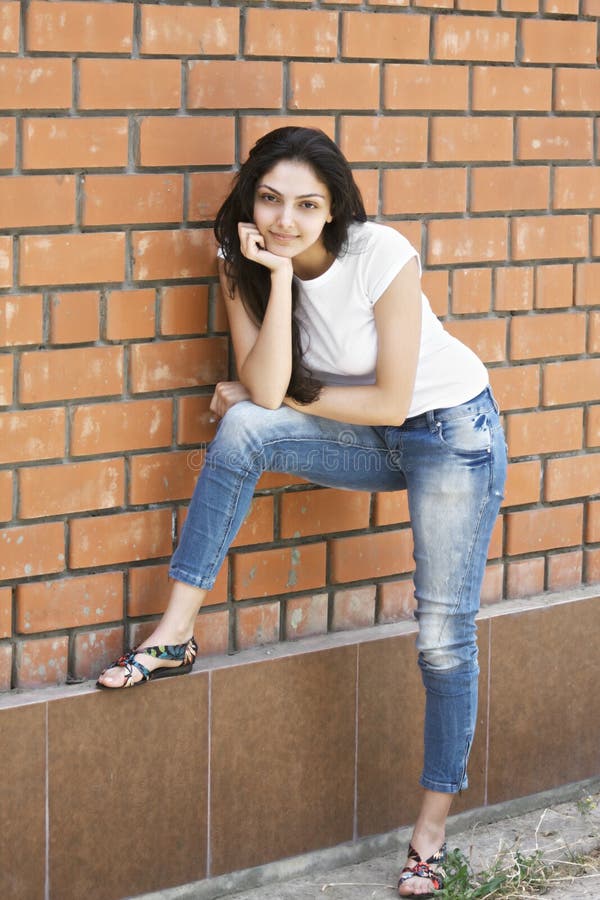 Young Brunette Standing at Wall Stock Photo - Image of wall, casual ...