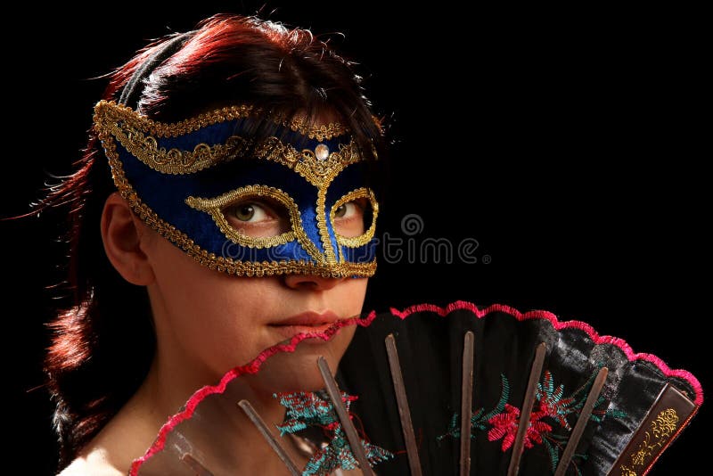 Young brunette with venetian mask and spanish fan