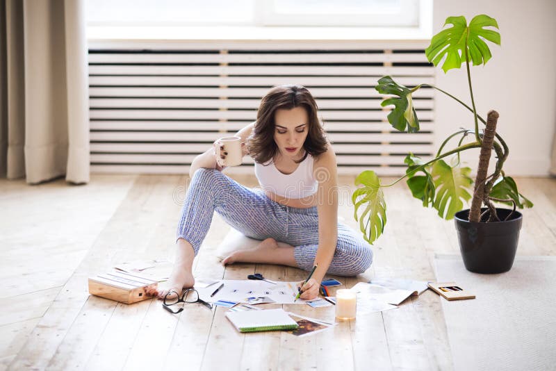 Young brunette woman creating her Feng Shui wish map using scissors