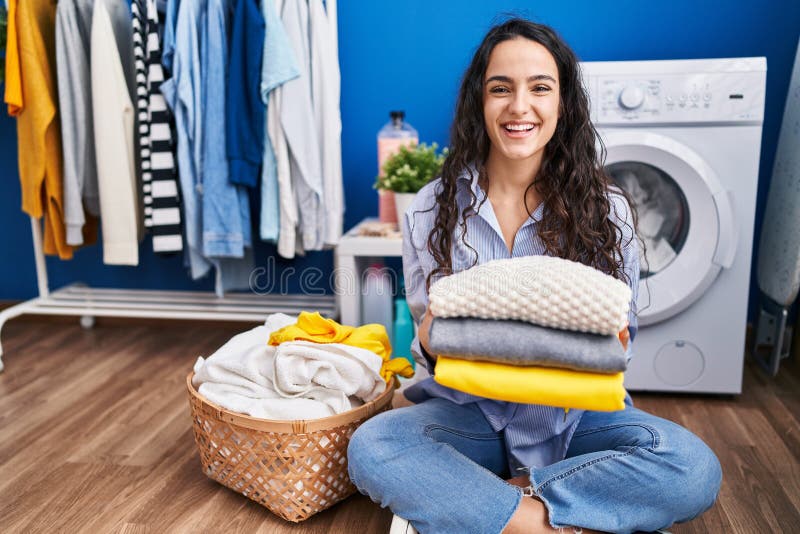 Young Brunette Woman Holding Clean Laundry Smiling and Laughing Hard ...