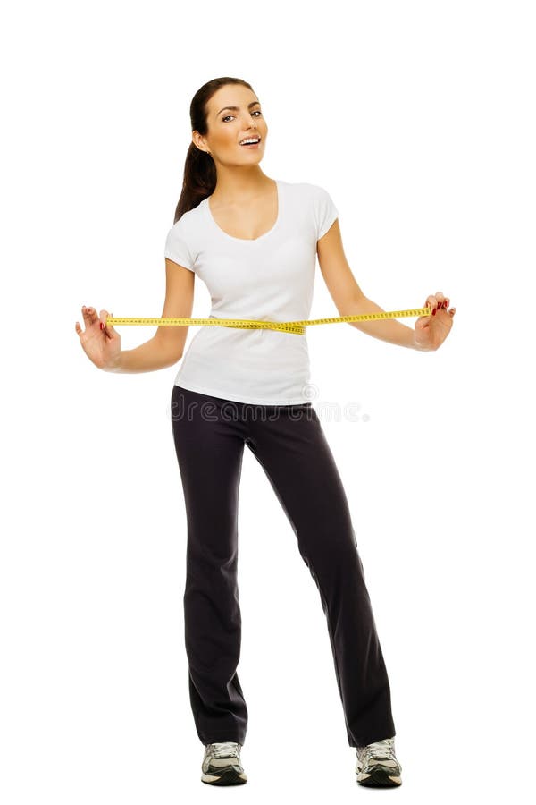 Young woman measuring her waistline with a measuring tape over white background. royalty free stock photos Young woman measuring her waistline with a measuring tape over white background. royalty free stock photos