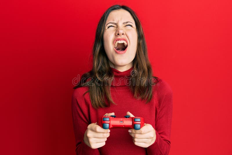 Angry woman playing online video games with joystick. Gamer using