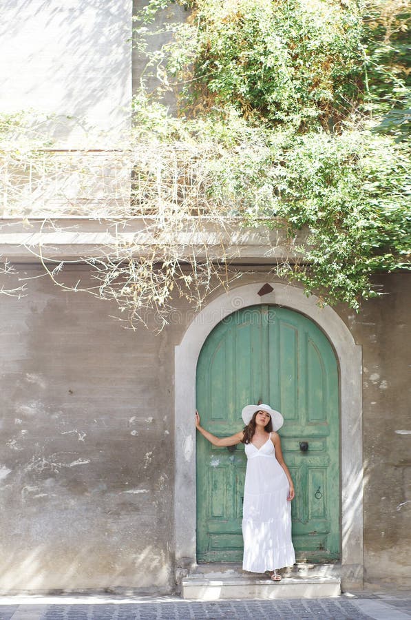 A young brunette woman in a white dress on a vacation