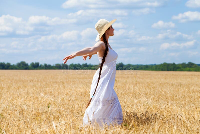 Young Brunette Woman In White Dress Walking In A Wheat Field Stock