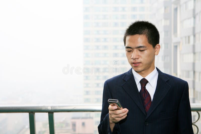 Young business man holding mobile phone