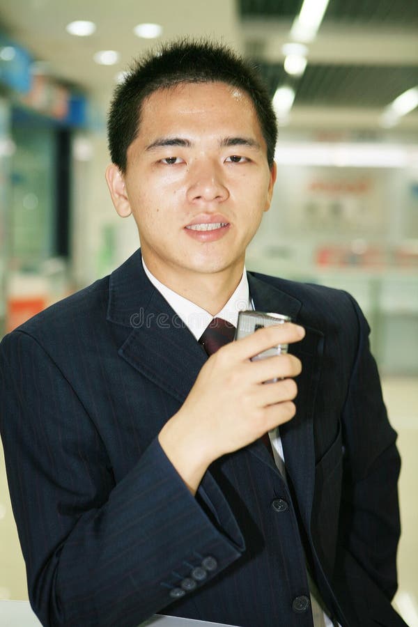 Young business man holding mobile phone