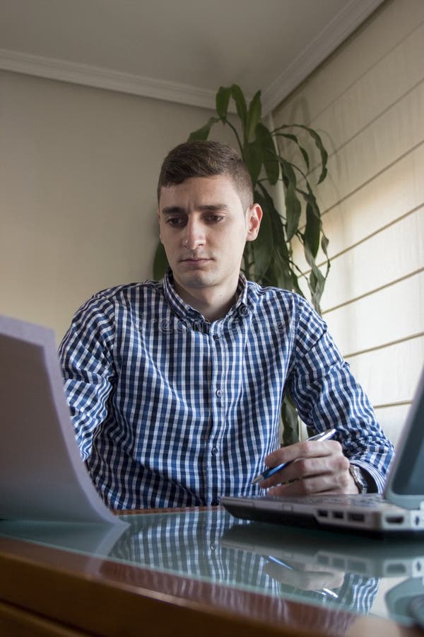 Young Business Man Reading Some Papers at Home Office Stock Photo