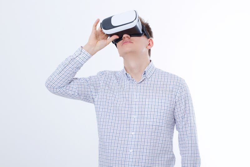 Young business man in vr glasses, goggles watching virtual reality isolated on white background. Copy space and mock up