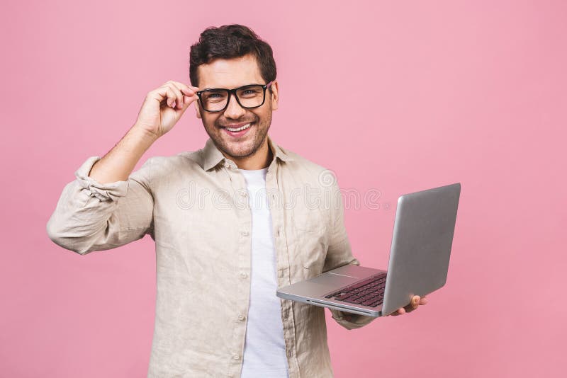 Young business man wearing glasses working using computer laptop with a smile isolated over pink background