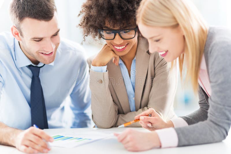 Young business people discussing in office, smiling