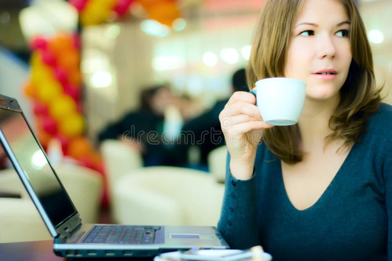 Young business woman drinking coffee and working o