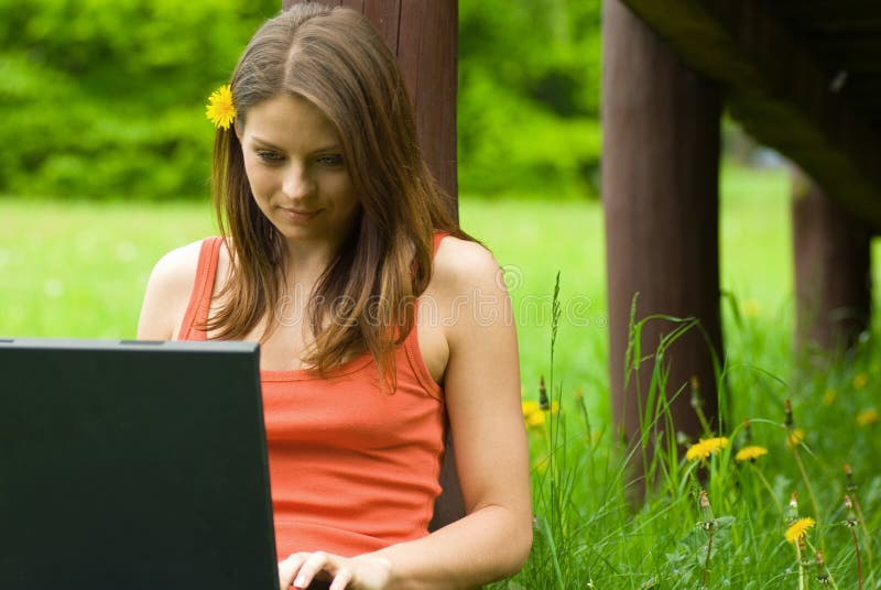 Joven mujer de negocios relajante, en negocios sobre el computadora portátil computadora sobre el prado.