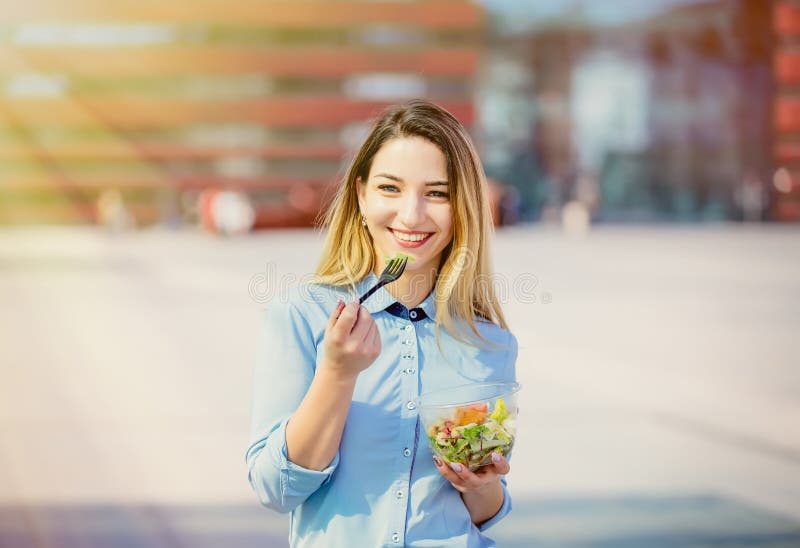 Young business woman with salad lunch box on outdoor stock image Young business woman with salad lunch box on outdoor stock image