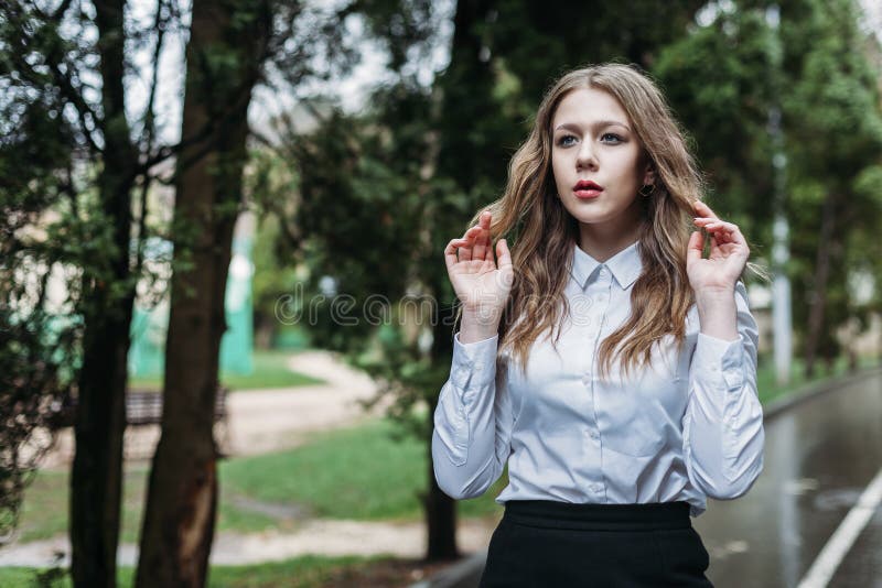 Young business woman in skirt posing outdoors in rain