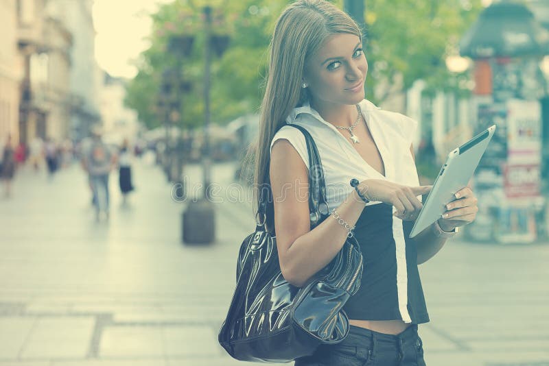 Young Business Woman with tablet computer walking on urban street royalty free stock images