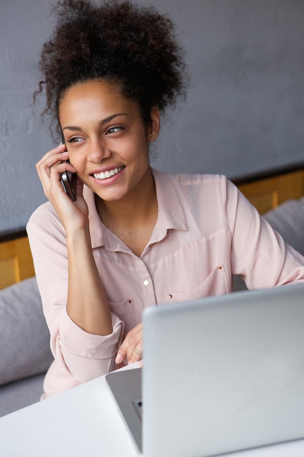 Young business woman talking on mobile phone with laptop