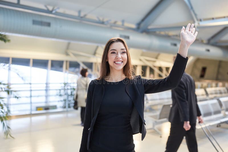 Young business woman while waving in the airport
