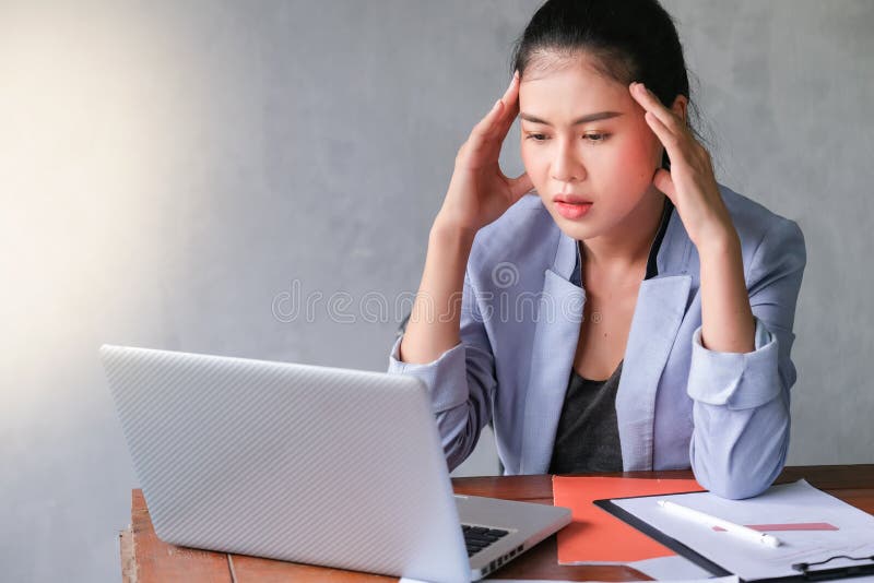 Young business women feeling headache and touching her temples