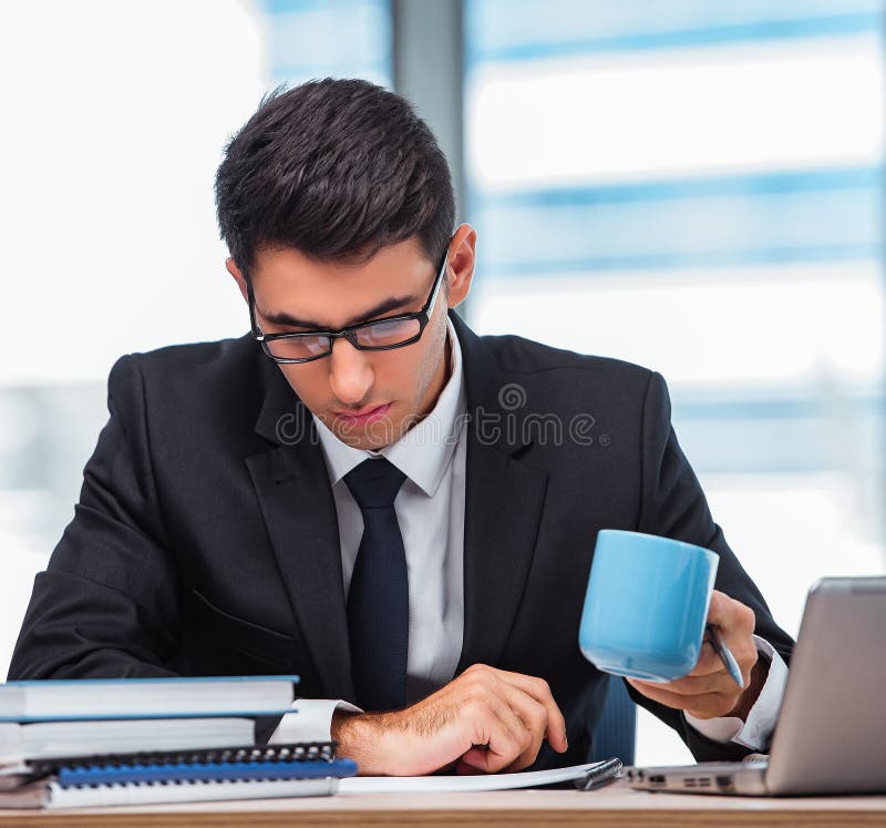 Young businessman drinking tea in the office royalty free stock image