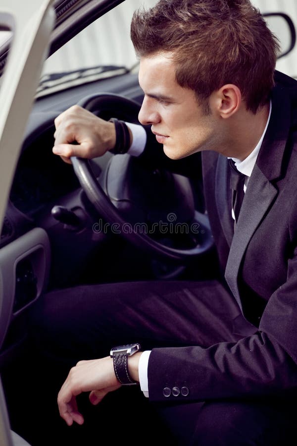 Young businessman in his car at the wheel