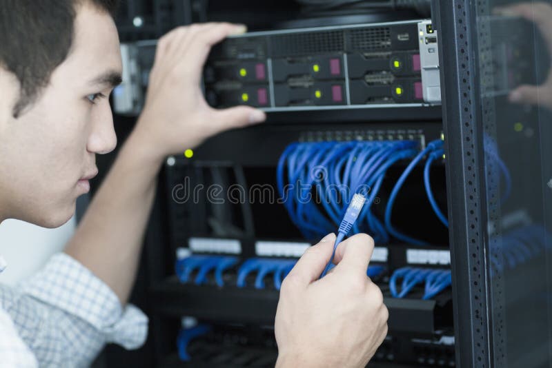 Young businessman holding and plugging in a computer cable royalty free stock photo