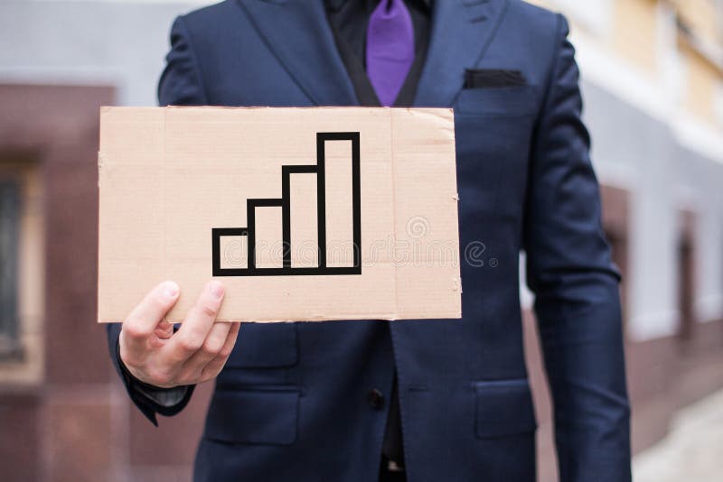 A young businessman holds a cardboard tablet with the concept of a career ladder in his hands royalty free stock photo A young businessman holds a cardboard tablet with the concept of a career ladder in his hands royalty free stock photo