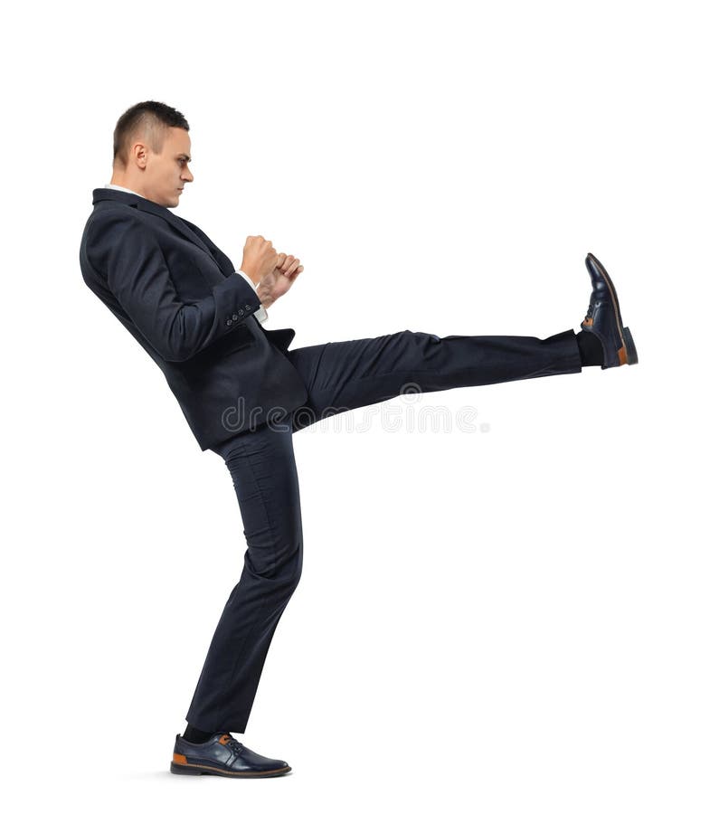 Young businessman kicking someone or something isolated on a white background. Struggling against something. Facing difficulties. Breaking barriers. Competitive spirit.