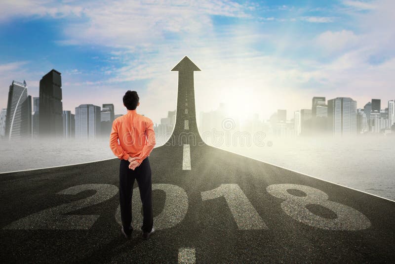 Young businessman looking at an upward arrow royalty free stock photo Young businessman looking at an upward arrow royalty free stock photo