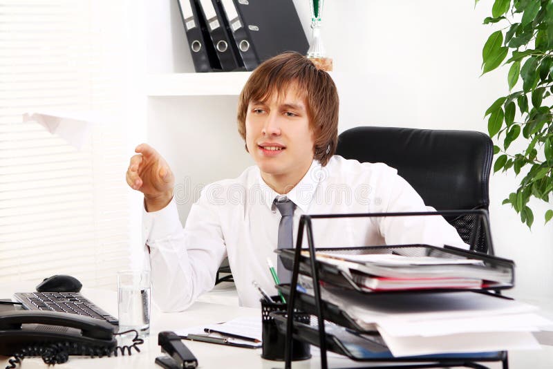 Young businessman playing with paper airplane