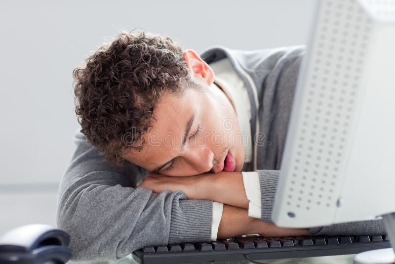 Young businessman sleeping on his desk in the office