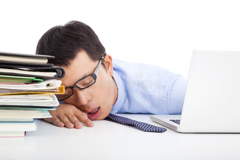 Young businessman too weary to asleep on the desk in office