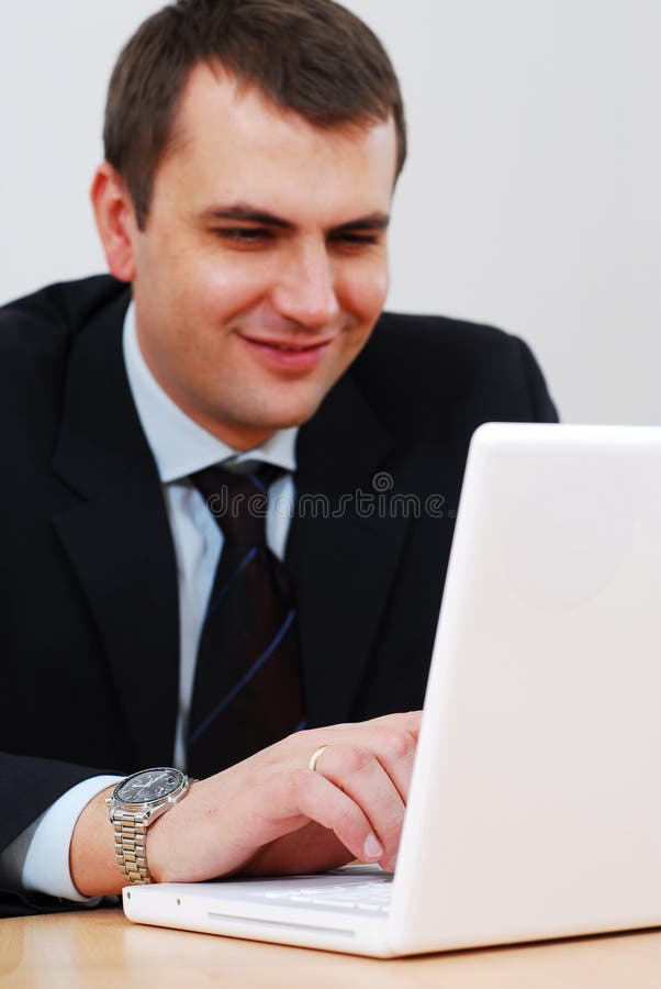 Young businessman working on lap-top and smiling. Top smiling cheerful stock images, royalty-free photos and pictures