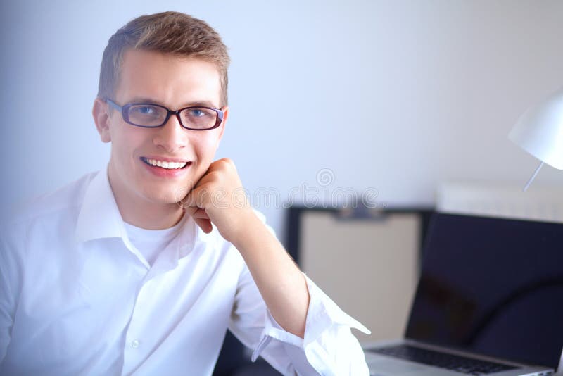Young businessman working in office, sitting near desk royalty free stock images Young businessman working in office, sitting near desk royalty free stock images