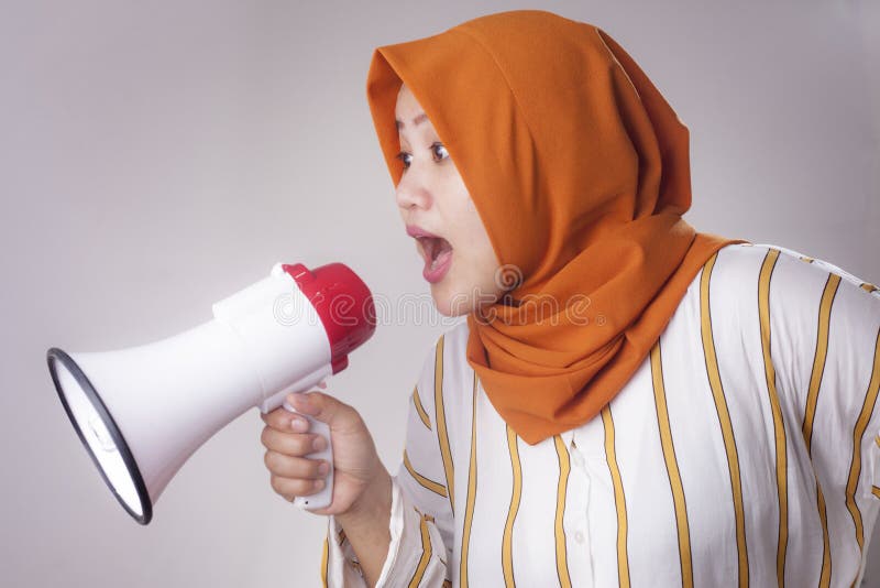 Young Asian businesswoman wearing suit and hijab screaming with an angry expression. Close up body portrait. Young Asian businesswoman wearing suit and hijab screaming with an angry expression. Close up body portrait