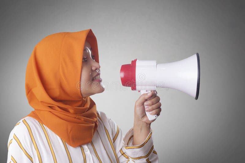 Young Asian businesswoman wearing suit and hijab screaming on megaphone with an angry expression. Close up body portrait veil muslim indonesian malaysian arab loudspeaker person female communication people corporate message shouting broadcasting formal manager speaking worker voice talking holding entrepreneur yelling attention news professional executive sound woman adult crazy job speech glasses employee cute. Young Asian businesswoman wearing suit and hijab screaming on megaphone with an angry expression. Close up body portrait veil muslim indonesian malaysian arab loudspeaker person female communication people corporate message shouting broadcasting formal manager speaking worker voice talking holding entrepreneur yelling attention news professional executive sound woman adult crazy job speech glasses employee cute