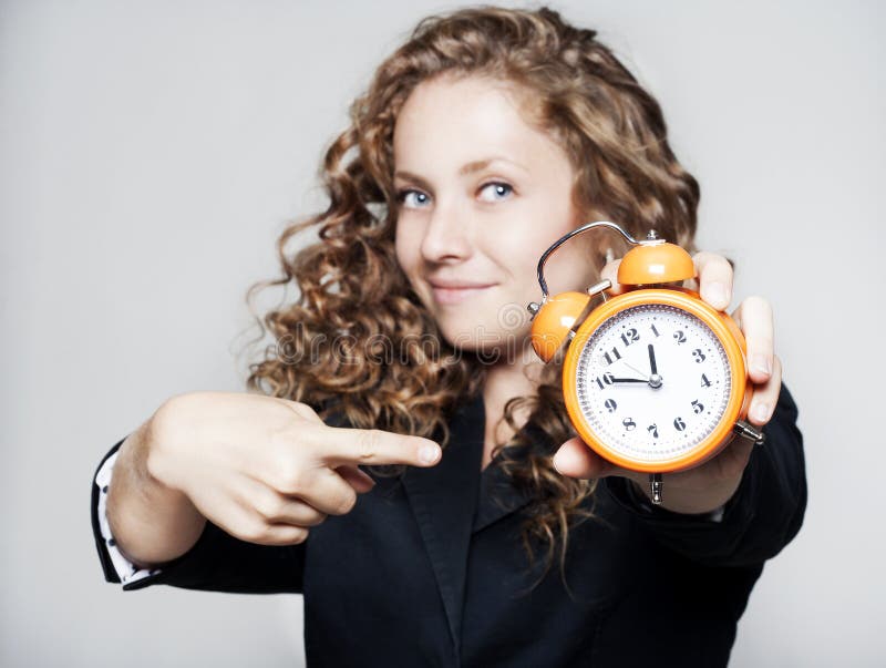 Young businesswoman holding a clock