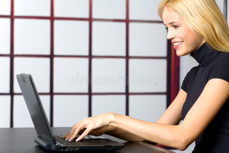 Young attractive happy smiling business woman or secretary on laptop, working, chatting, walking at the net. Young attractive happy smiling business woman or secretary on laptop, working, chatting, walking at the net