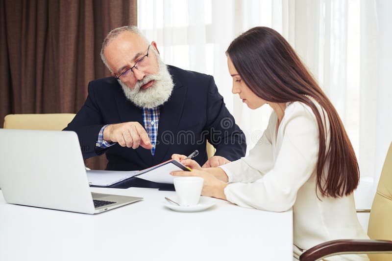 Young Businesswoman And Senior Man Working And Planning In The M