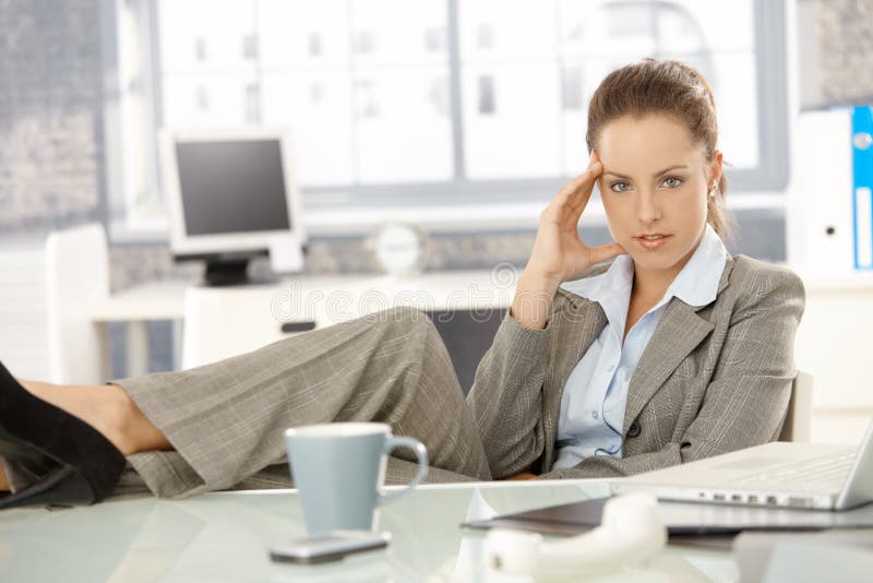 Young businesswoman sitting tired in office