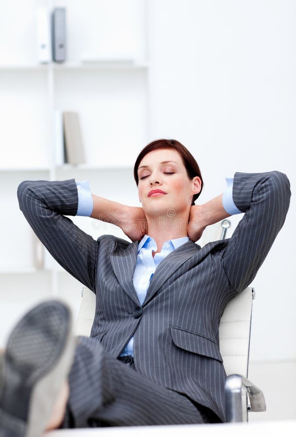 Young Businesswoman sleeping with feet on desk in the office