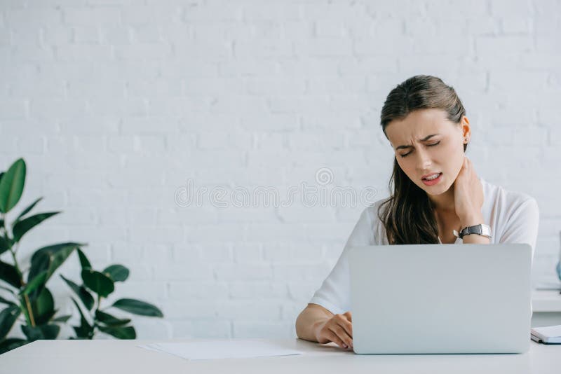 young businesswoman suffering from neck pain while working stock photos young businesswoman suffering from neck pain while working stock photos