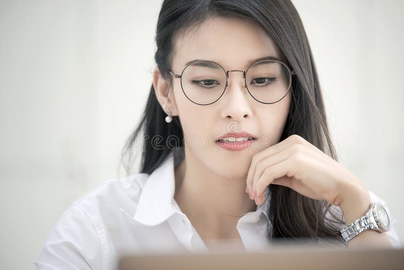 Young businesswoman wearing glasses working with computer in modern office